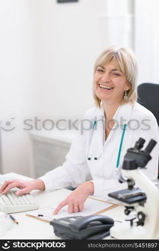 Happy middle age doctor woman at work