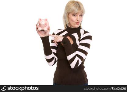 Happy middle age woman pointing on piggy bank
