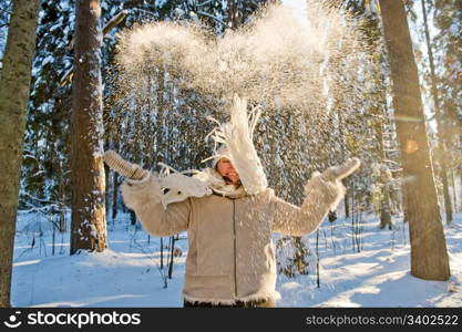 Happy middle-aged woman having fun on winters day in forest.