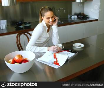 Happy middle woman enjoying a conversation while preparing a coffee