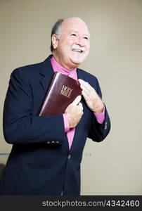 Happy minister holding the Bible and preaching a message of love.