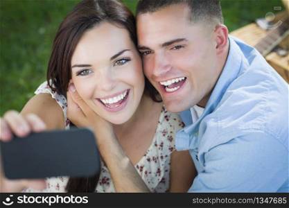 Happy Mixed Race Couple Taking Self Portrait with A Smart Phone in the Park.