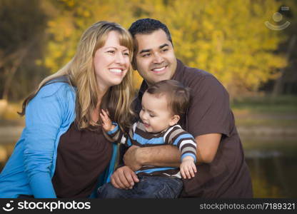 Happy Mixed Race Ethnic Family Having Fun Playing In The Park.