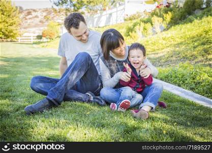 Happy Mixed Race Family Having Fun Outside on the Grass.