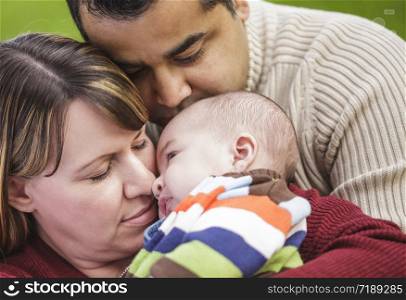 Happy Mixed Race Parents Hugging Their Son in the Park.