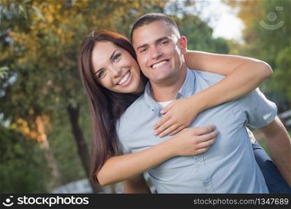 Happy Mixed Race Romantic Couple Piggyback Portrait in the Park.