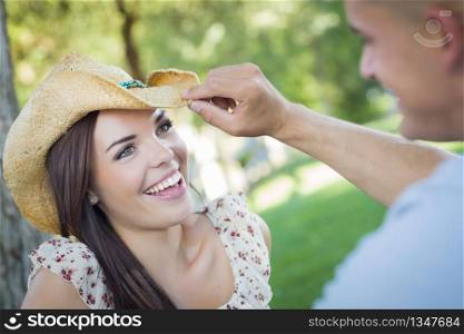 Happy Mixed Race Romantic Couple with Cowboy Hat Flirting in the Park.
