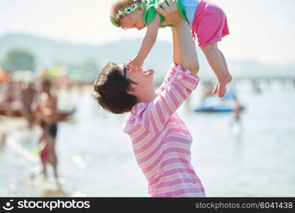 happy mom and baby on beach have fun while learning to walk and make first steps