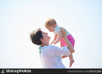 happy mom and baby on beach have fun while learning to walk and make first steps