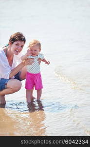 happy mom and baby on beach have fun while learning to walk and make first steps