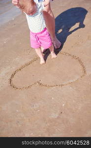 happy mom and baby on beach have fun while learning to walk and make first steps