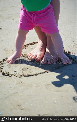 happy mom and baby on beach have fun while learning to walk and make first steps