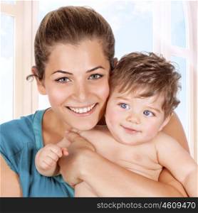 Happy mother and baby boy enjoying time at home, having fun together, close-up portrait on smiling pretty faces, healthy cheerful family