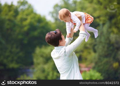 happy mother and baby child in park making first steps . Walking and hugging.