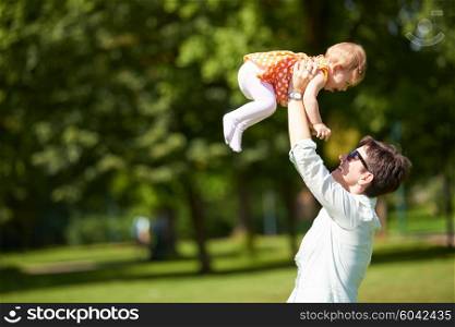 happy mother and baby child in park making first steps . Walking and hugging.