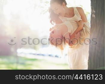 Happy mother and baby having fun near tree
