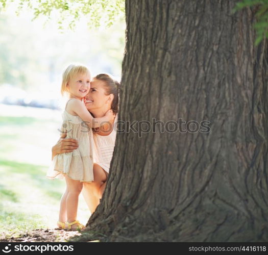 Happy mother and baby near tree