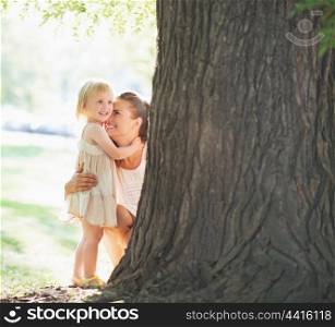 Happy mother and baby near tree
