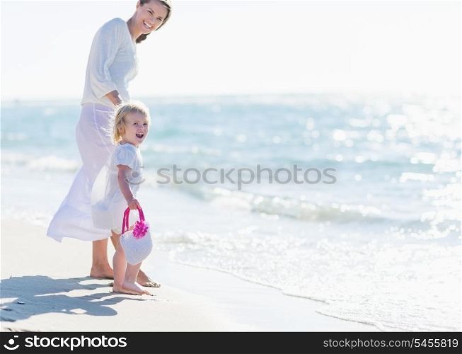 Happy mother and baby on sea shore