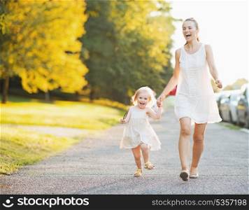 Happy mother and baby walking in city