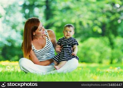 Happy mother and daughter on grass