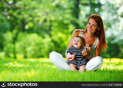 Happy mother and daughter on the green grass