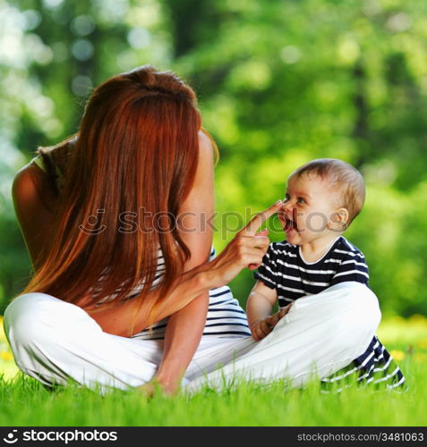 Happy mother and daughter on the green grass