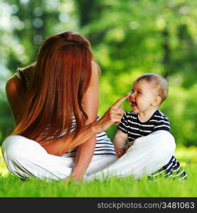 Happy mother and daughter on the green grass