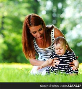 Happy mother and daughter on the green grass