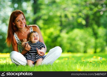 Happy mother and daughter on the green grass