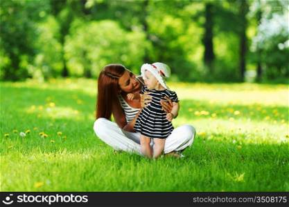 Happy mother and daughter on the green grass