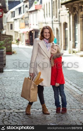 happy mother and daughter stroll around the old city Morlaix, france