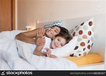Happy mother and daughter together on bed