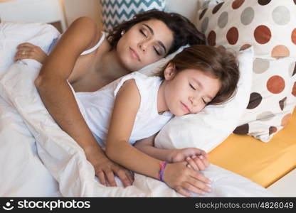 Happy mother and daughter together on bed