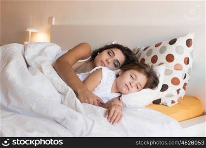 Happy mother and daughter together on bed