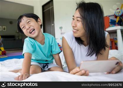 happy mother and her son Taking pictures or selfie or video call or relatives in a bed. Concept of new generation, family, parenthood, authenticity, connection