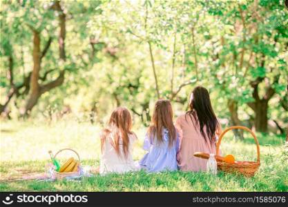 Happy mother and little daughers on picnic in the park. Happy mother and little daughers relax by the lake