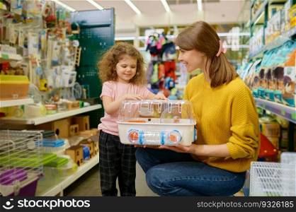 Happy mother and little daughter buying hamster cage at pet shop. Family shopping time on weekend. Happy mother and little daughter buying hamster cage at pet shop