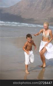 Happy Mother and son play on the beach