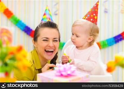 Happy mother celebrating first birthday of her baby