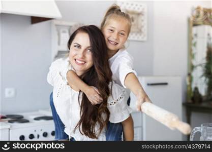 happy mother daughter posing with kitchen roller