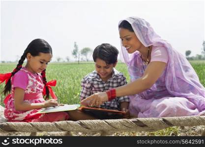 Happy mother guiding children with their homework