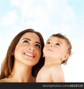Happy mother holding baby boy, cute kid, smiling faces looking up, family enjoying summer outdoor, mom and child over blue sky nature background, pretty Arabic mommy with son, happiness concept