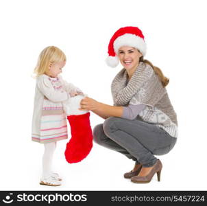 Happy mother holding Christmas sock while baby girl taking out present