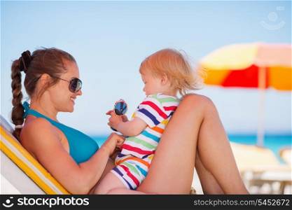 Happy mother in sunglasses playing with baby