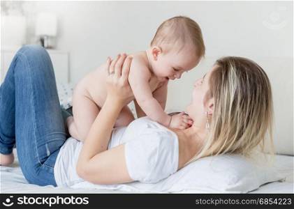 Happy mother kissing 9 months old baby in head