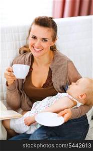 Happy mother resting while baby sleep by having tea and reading book&#xA;