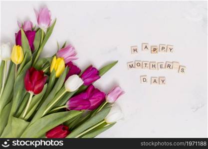 happy mother s day text with colorful tulip flowers white concrete background. High resolution photo. happy mother s day text with colorful tulip flowers white concrete background. High quality photo