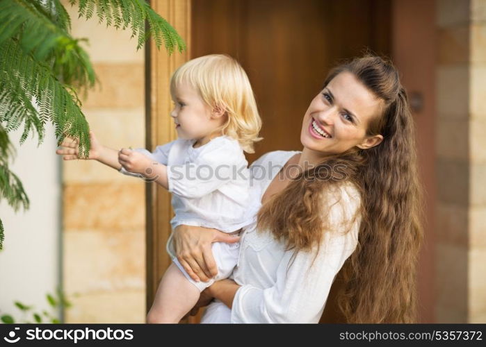 Happy mother showing baby plants outdoors