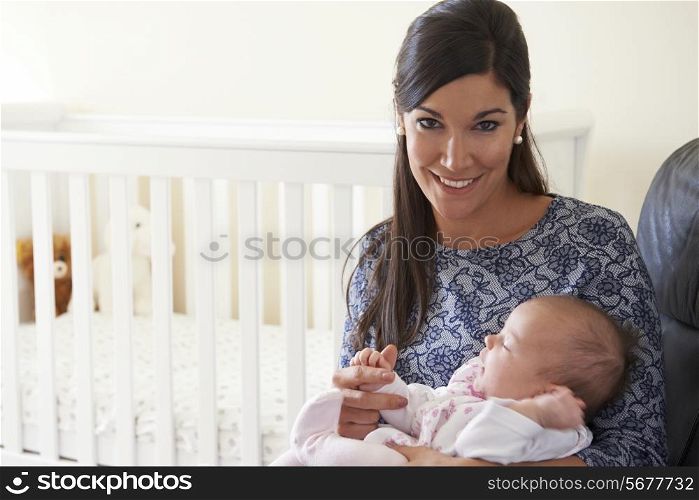 Happy Mother Sitting In Nursery With Baby